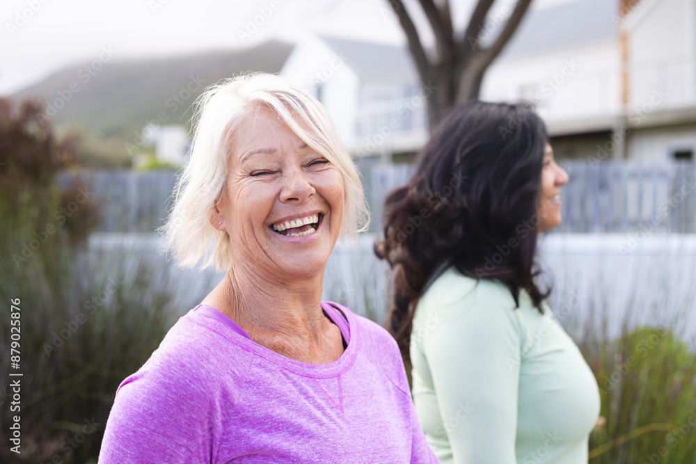 Portrait of happy diverse senior woman and female friend walking for exercise in country road Portrait of happy diverse senior woman and female friend walking for exercise in country road