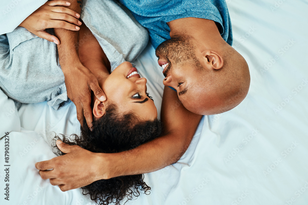 Fototapeta premium Cuddle, happy and above of couple in bed in morning for bonding, relationship and love. Marriage, home and man and woman in bedroom embrace for comfort, resting and affection for trust and care