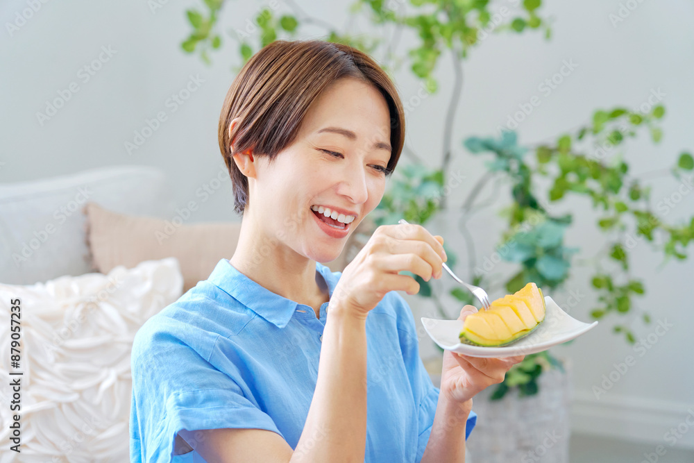 自宅でメロンを食べる女性