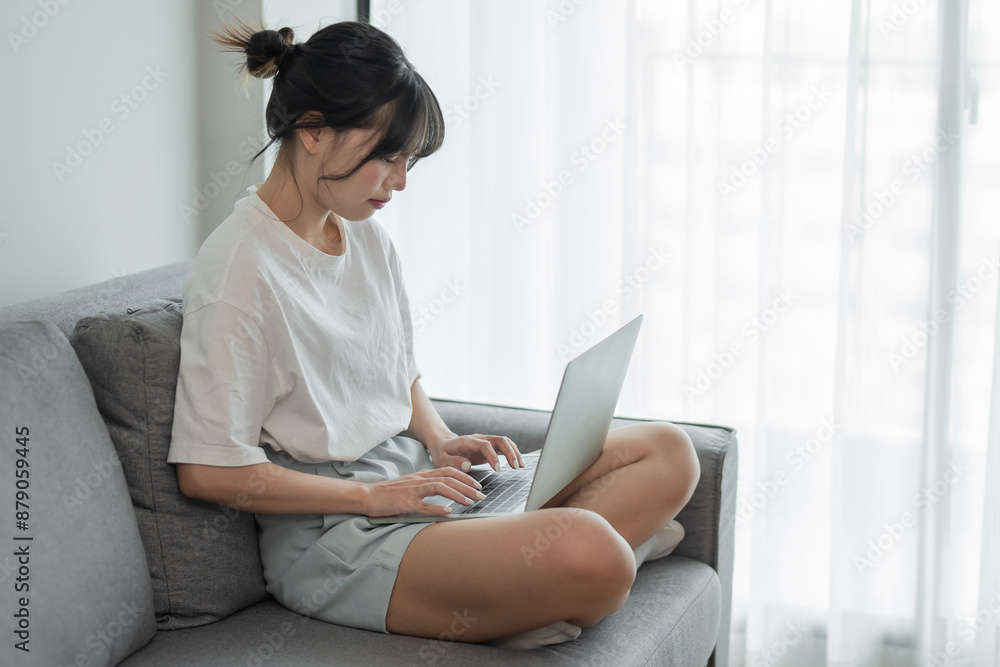 Business woman working from home. work online on laptop. Asian businesswoman working on sofa online business with social distancing laptop online meeting Business woman working from home. work online on laptop. Asian businesswoman working on sofa online business with social distancing laptop online meeting