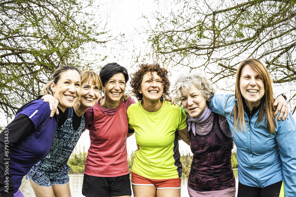 Group of smiling women of various ages in athletic wear enjoying outdoor exercise together. They are embracing each other in a park setting. Concept of friendship, fitness, and healthy lifestyle. Group of smiling women of various ages in athletic wear enjoying outdoor exercise together. They are embracing each other in a park setting. Concept of friendship, fitness, and healthy lifestyle.
