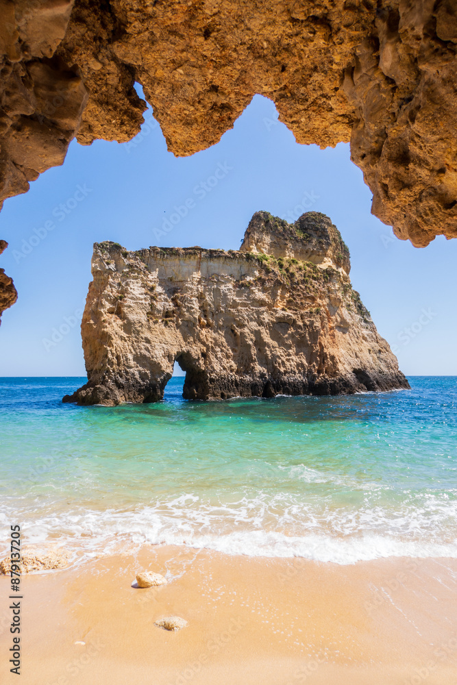 Fototapeta premium Small, heavenly beach vertically photographed from inside the rocks near Portimão, Algarve, Portugal