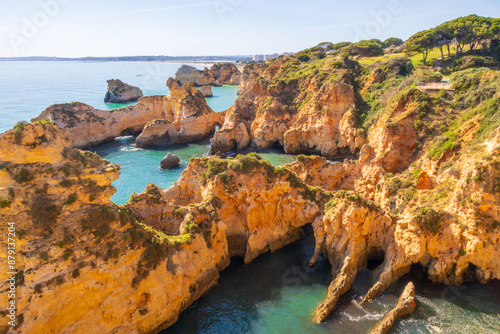 Over the jagged cliffs of Praia do Ferta beach near Alvor, Portugal photo