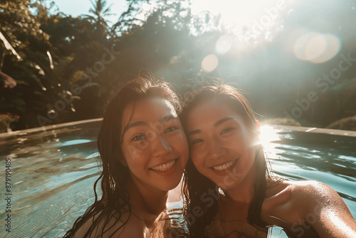 selfie of two young asian friends having fun in the water