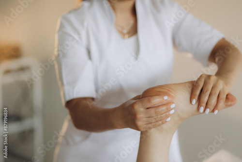 A close-up view of a foot massage in progress, highlighting the skilled hands of the therapist as they apply pressure to the clients foot. © Roman