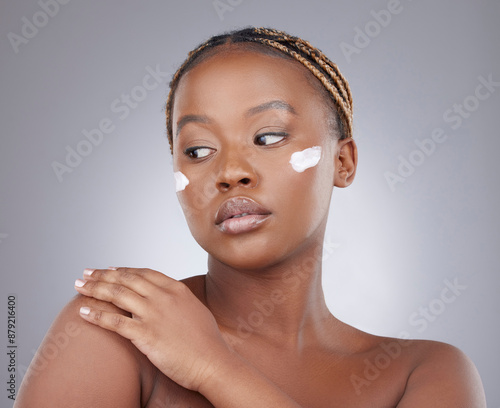 Face cream, beauty and black woman in studio for facial, wellness and skincare on gray background. Dermatology, salon treatment and isolated person with moisturizer, lotion and anti aging cosmetics