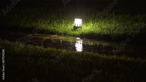 4K: Rainy night scene in Georgia, with raindrops falling on the garden ground light. photo