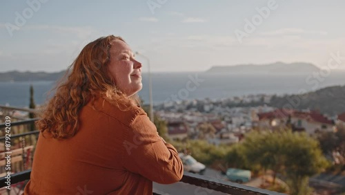 Woman enjoying sunset view, in coastal resort town