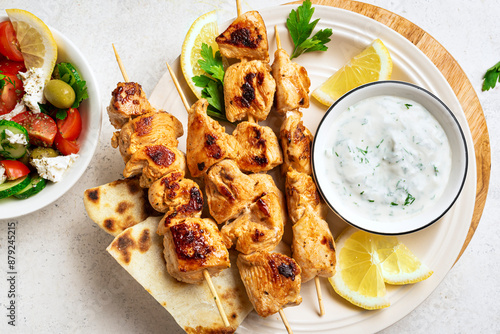 Grilled souvlaki skewers, greek salad and tzatziki photo