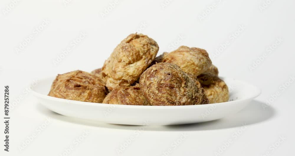 Hand serving ooty varkey pastry tea snacks on white plate against white background. Closeup Hand serving ooty varkey pastry tea snacks on white plate against white background. Closeup
