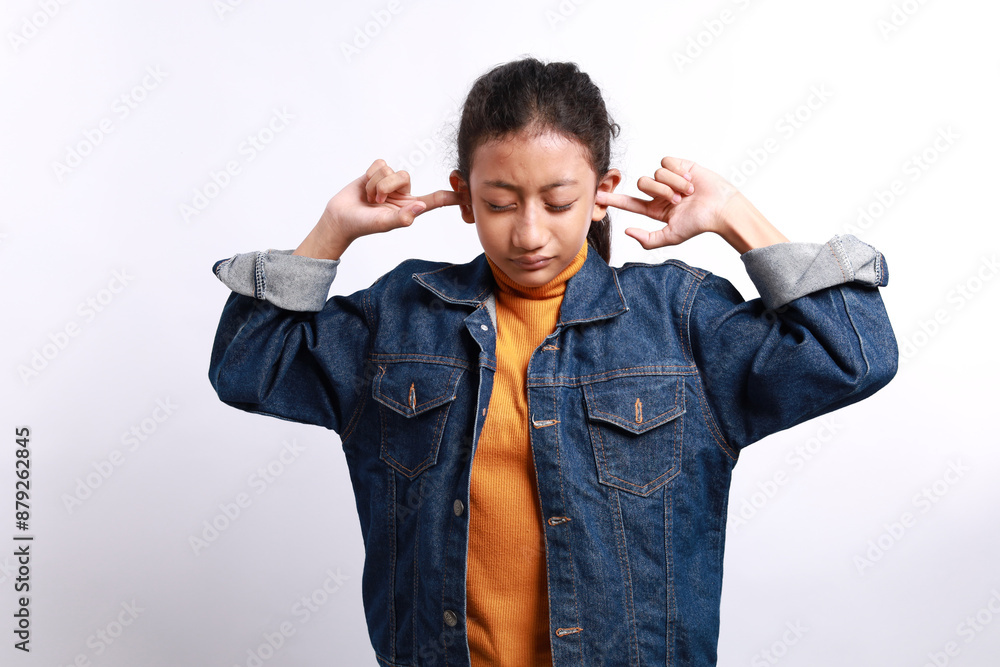 little child girl closing eyes and discontentedly closing ears with hands, irritated. nervous girl doesn't want to hear parents' quarrel, ignoring the notice of mommy. isolated on white little child girl closing eyes and discontentedly closing ears with hands, irritated. nervous girl doesn't want to hear parents' quarrel, ignoring the notice of mommy. isolated on white