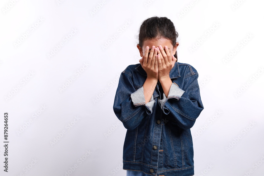 Stressed asian girl standing while covering his face with his hands. Isolated on white background Stressed asian girl standing while covering his face with his hands. Isolated on white background