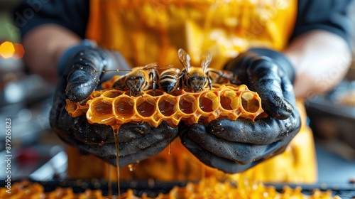 Close-up of gloved hands holding a honeycomb filled with bees and fresh honey, showcasing the craftsmanship of beekeeping. photo