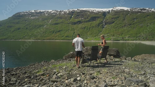 Couple enjoys green smoothies by Roldalsvatnet lake with stunning mountain views in Norway photo