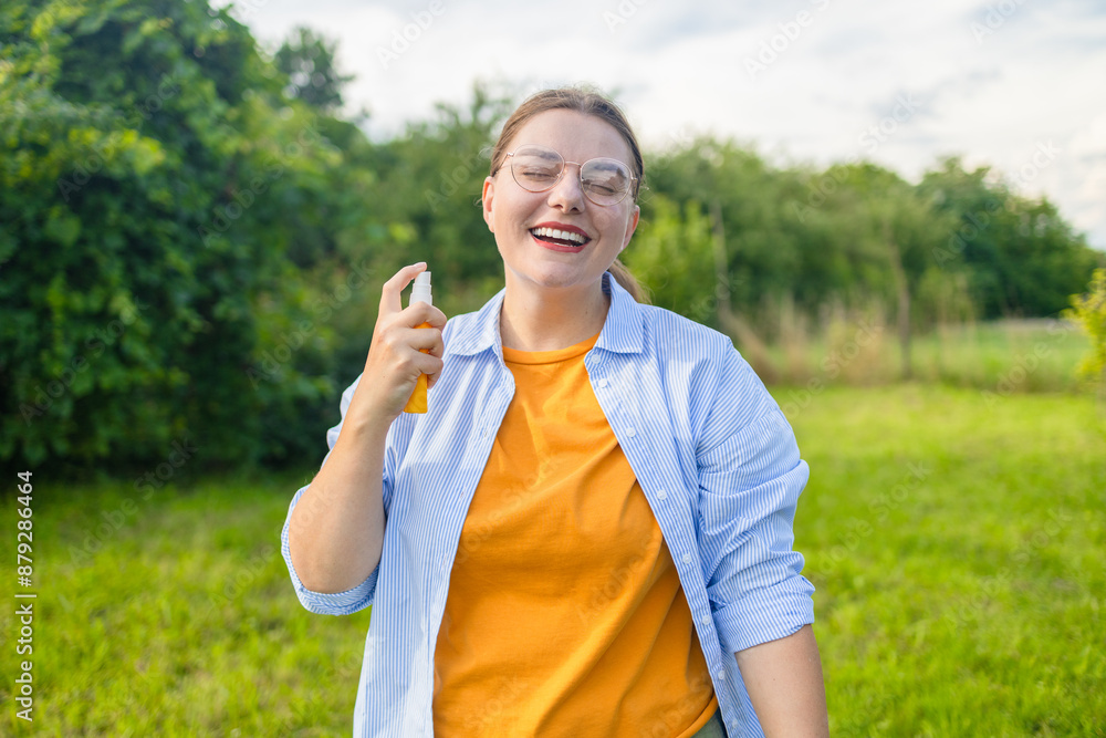 Woman spraying insect repellent or bug spray to her hand at park. High quality photo Woman spraying insect repellent or bug spray to her hand at park. High quality photo