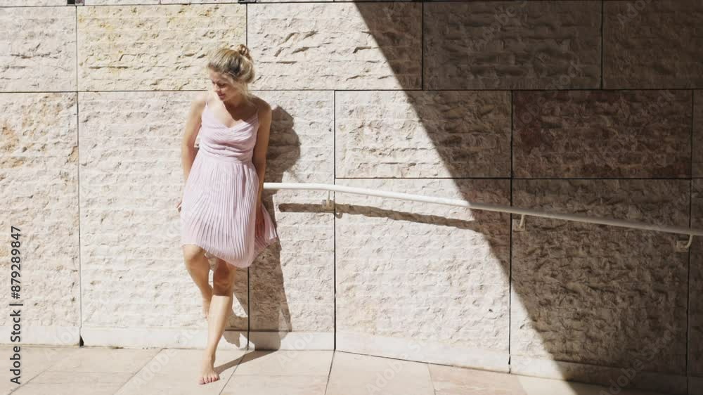 Woman Dancing in Pink Dress by Stone Wall Woman Dancing in Pink Dress by Stone Wall
