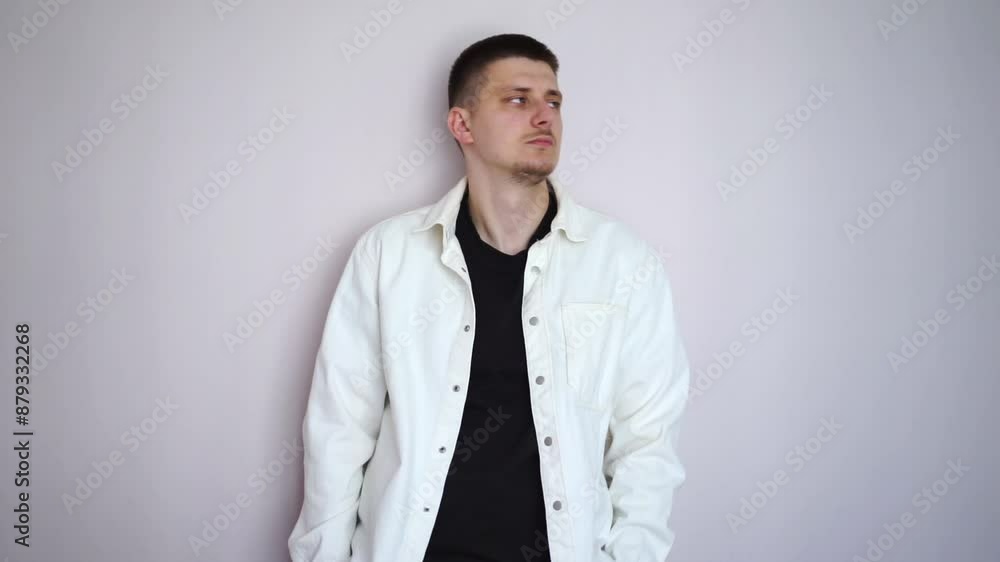 a man stands against the wall.
A serious man without emotion stands against the wall a man stands against the wall.
A serious man without emotion stands against the wall