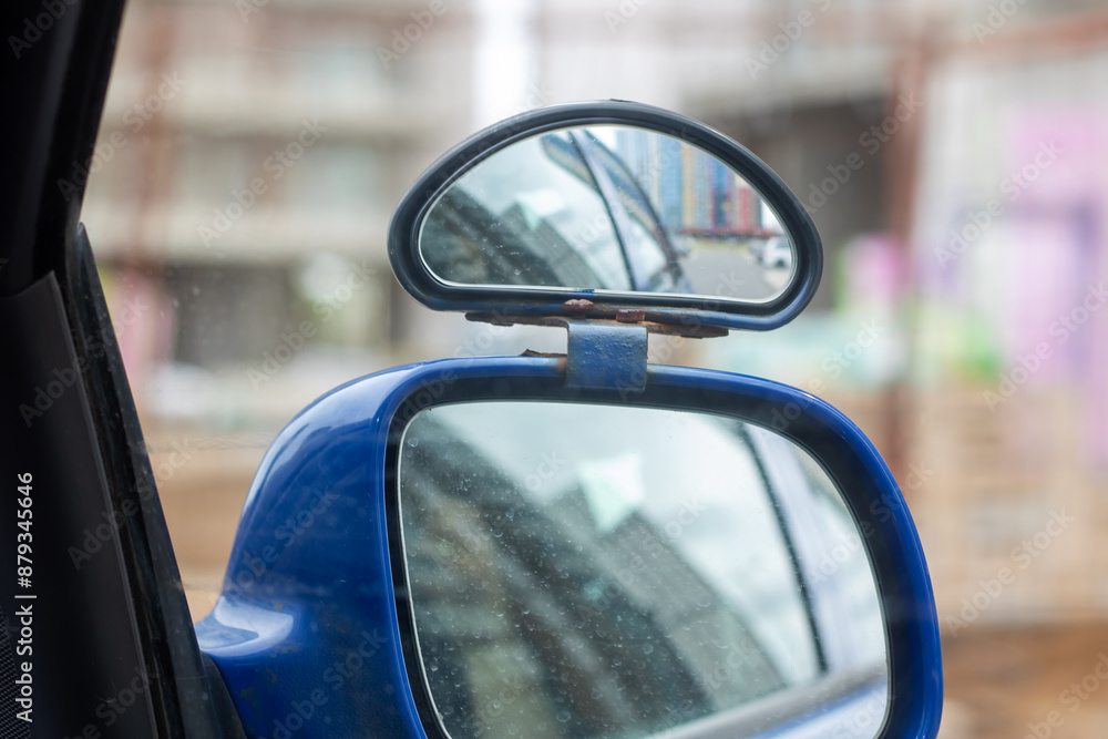 A blue car with a rear view mirror attached to it A blue car with a rear view mirror attached to it