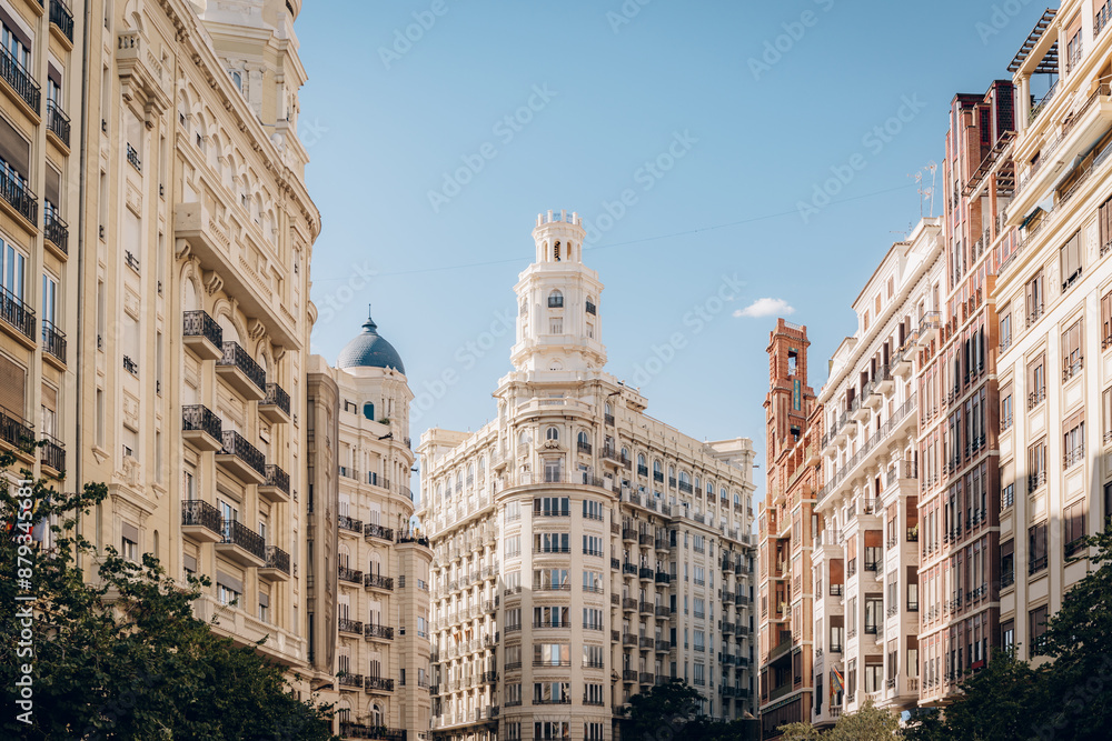 Elegant historic buildings with intricate facades and balconies under a clear blue sky in Valencia. The urban landscape highlights the city architectural beauty and charm. Elegant historic buildings with intricate facades and balconies under a clear blue sky in Valencia. The urban landscape highlights the city architectural beauty and charm.