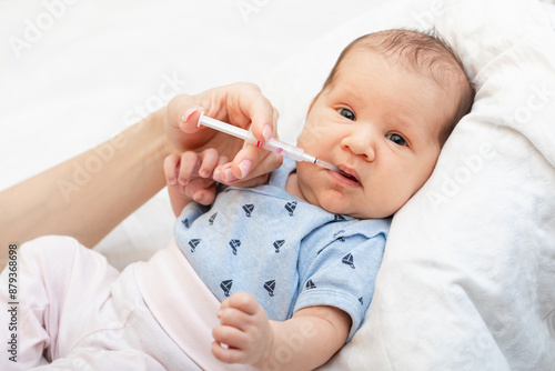 Photography Mother feeding newborn baby with liquid Vitamin K