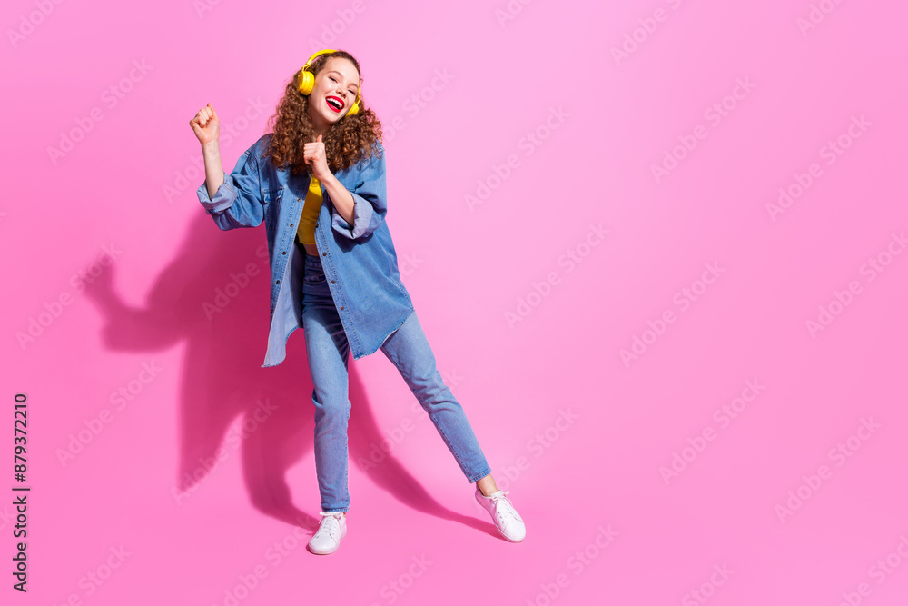 Full length photo of shiny attractive lady dressed denim jacket earphones having fun empty space isolated pink color background Full length photo of shiny attractive lady dressed denim jacket earphones having fun empty space isolated pink color background