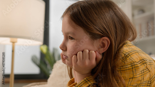 Foto Frustrated pensive bored Caucasian girl child punished for bad grades at school suffering alone abused at home