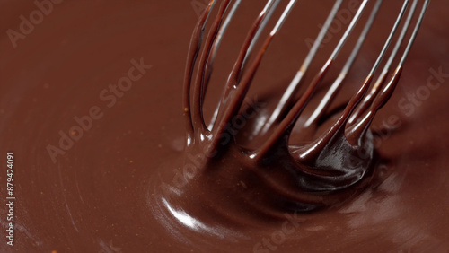 Smooth chocolate sauce being whisked.