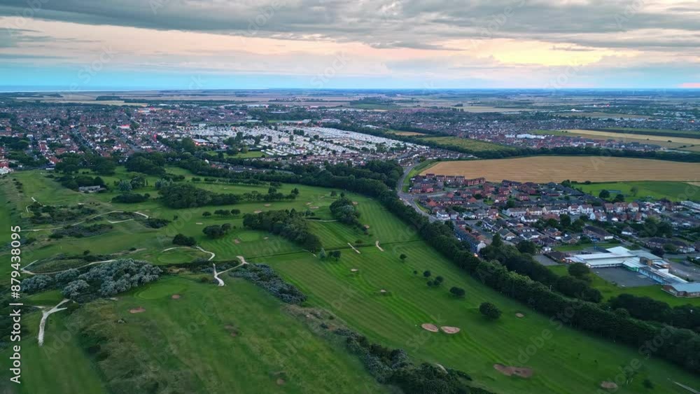 Aerial perspective: Skegness coastal town captured by drone at summer sunset. Video displays holiday park, sea, beach, caravans