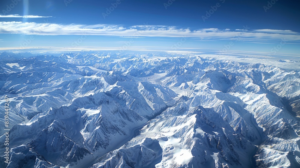 Fototapeta premium A high-altitude aerial photograph of a vast mountain range, with snow-capped peaks and glacial valleys