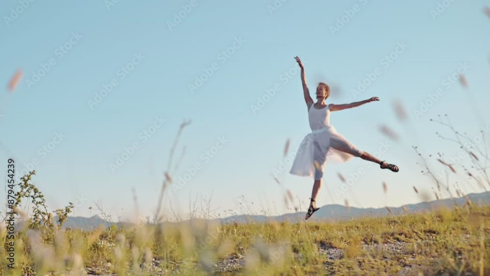 The splendor of free dance. A chic young woman in a white dress dances ballet in the rays of a summer sunset and smiles against the background of a natural landscape of a mountain range. Slow motion The splendor of free dance. A chic young woman in a white dress dances ballet in the rays of a summer sunset and smiles against the background of a natural landscape of a mountain range. Slow motion