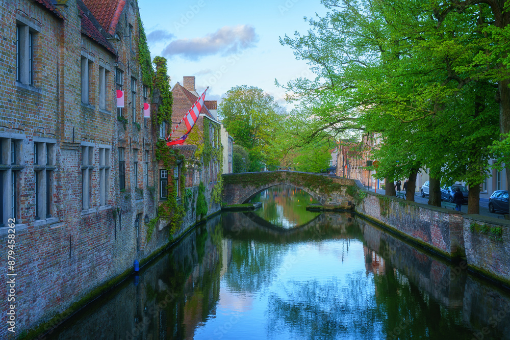 Naklejka premium Old Town of Bruges, Belgium, famous landmark. Scenic cityscape with medieval historical buildings along the Groenerei canal at sunset, outdoor travel background