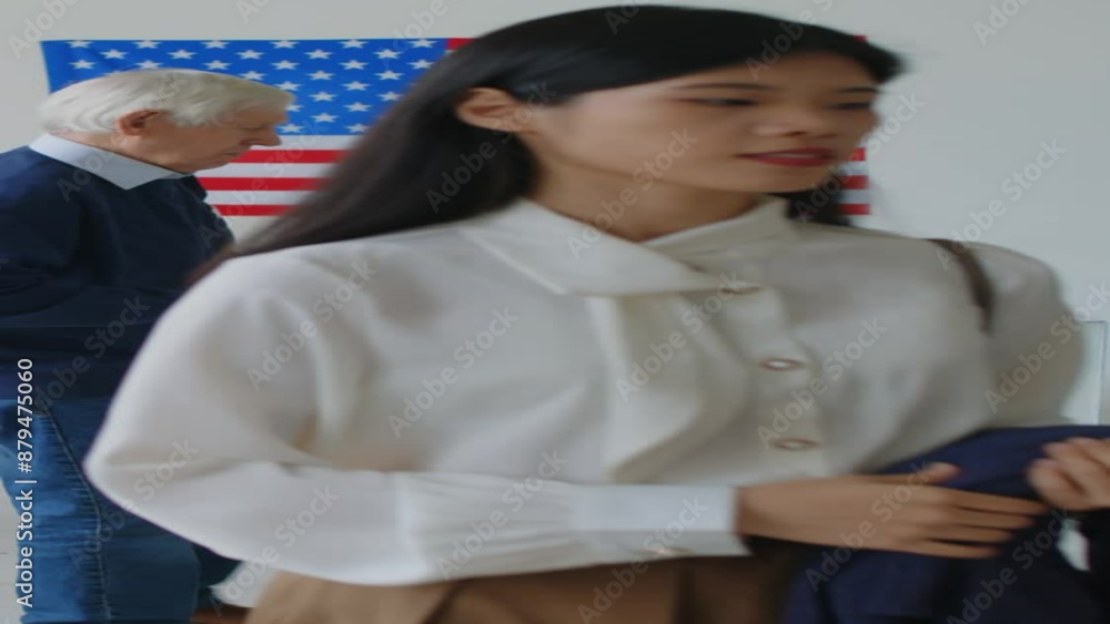 Vertical shot of young Asian woman and senior Caucasian man putting voting slips into ballot box, then leaving polling station Vertical shot of young Asian woman and senior Caucasian man putting voting slips into ballot box, then leaving polling station
