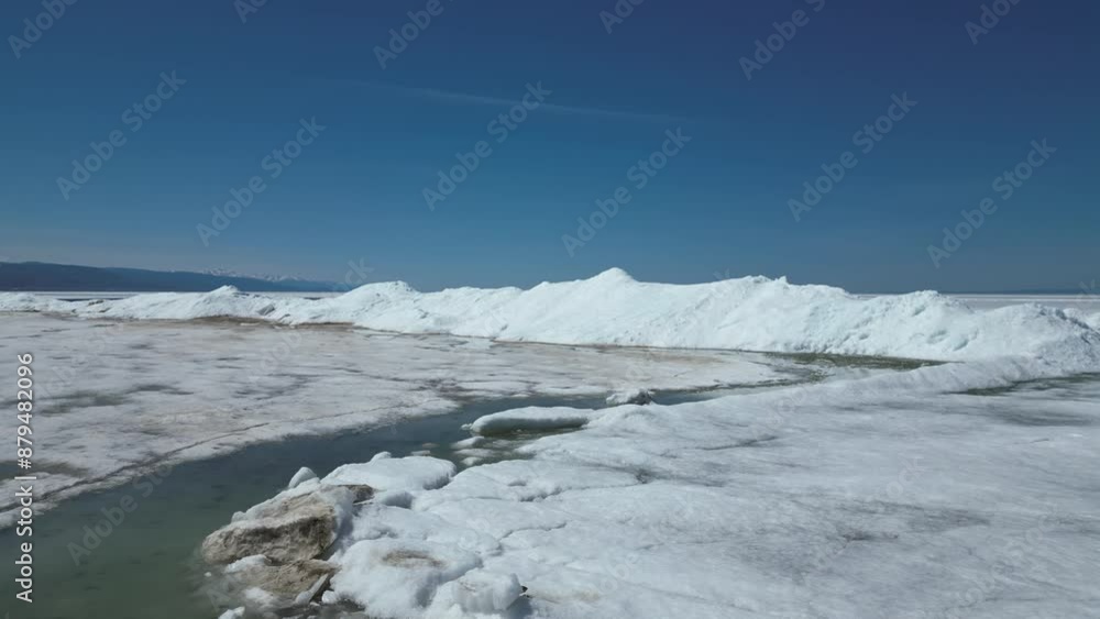 The camera flies low over the glacier towards the snowy ridge on a clear sunny day against a blue cloudless sky. Global warming, melting of glaciers. High quality 4k footage The camera flies low over the glacier towards the snowy ridge on a clear sunny day against a blue cloudless sky. Global warming, melting of glaciers. High quality 4k footage