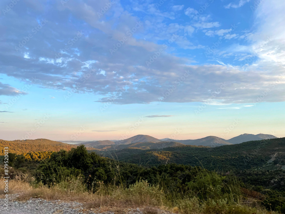Fototapeta premium Beautiful blue sky with clouds over mountains and greenery