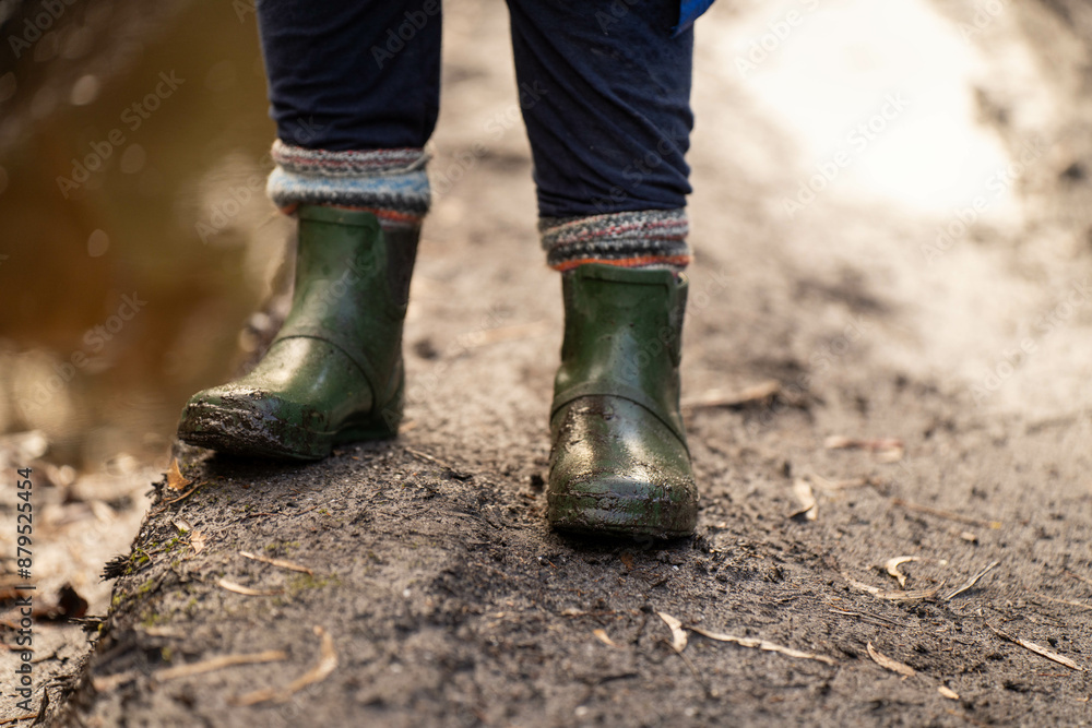 muddy boots of gumboots and wellies on a walk with mud and water in winter
