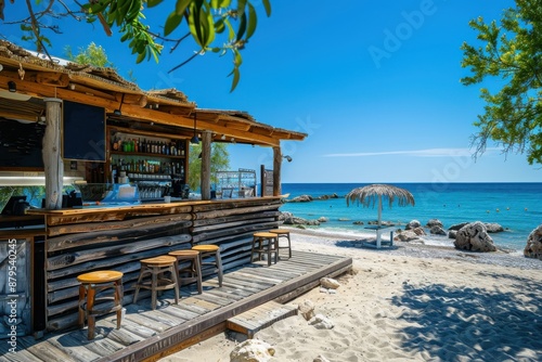 A cozy seaside bar with wooden stools and overhead thatch roof, offering breathtaking views of the ocean with clear skies, inviting relaxation and enjoyment. photo