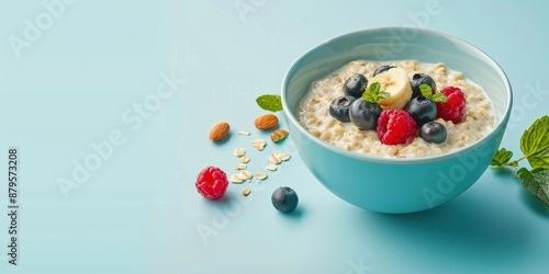 Nutritious Breakfast Concept - Delicious Oatmeal with Fresh Berries and Nuts on Plain Background for Copy Space