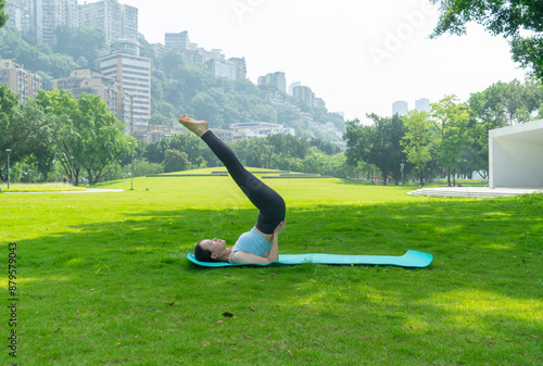 Young women doing yoga on the park lawn