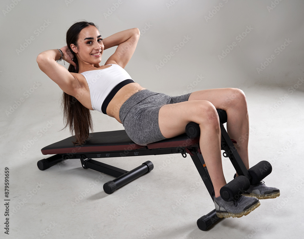 Fitness girl doing abs crunches on the bench Fitness girl doing abs crunches on the bench