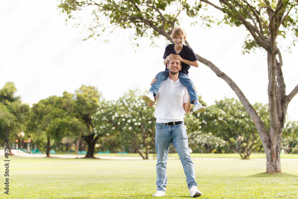 Man piggyback his son on a shoulder and walking around the park. Man piggyback his son on a shoulder and walking around the park.