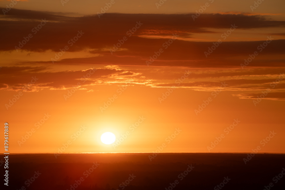 A radiant sunset over a forested horizon, with the sun casting a warm, golden glow across the sky and landscape. The vibrant orange and yellow hues create a stunning and tranquil scene. Copy space. A radiant sunset over a forested horizon, with the sun casting a warm, golden glow across the sky and landscape. The vibrant orange and yellow hues create a stunning and tranquil scene. Copy space.