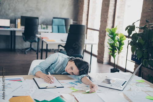 Photo of attractive young woman lying tired table dressed denim clothes executive business leader work comfort beautiful office interior