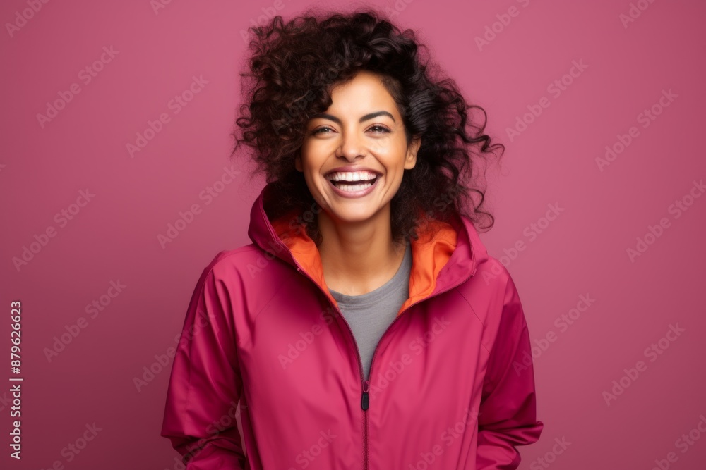 Portrait of a happy indian woman in her 30s wearing a functional windbreaker in solid color backdrop Portrait of a happy indian woman in her 30s wearing a functional windbreaker in solid color backdrop
