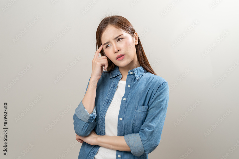 Thoughtful Young woman frowning her eyebrows holding index finger on chin having doubt and suspicion feeling sceptical about something. Human emotions and expressions Thoughtful Young woman frowning her eyebrows holding index finger on chin having doubt and suspicion feeling sceptical about something. Human emotions and expressions