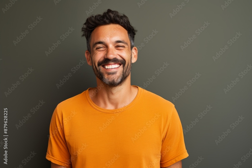 Portrait of a smiling man in his 30s donning a trendy cropped top over solid color backdrop Portrait of a smiling man in his 30s donning a trendy cropped top over solid color backdrop