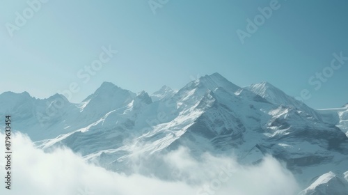 A breathtaking view of snow-covered mountain peaks, bathed in soft sunlight against a clear blue sky