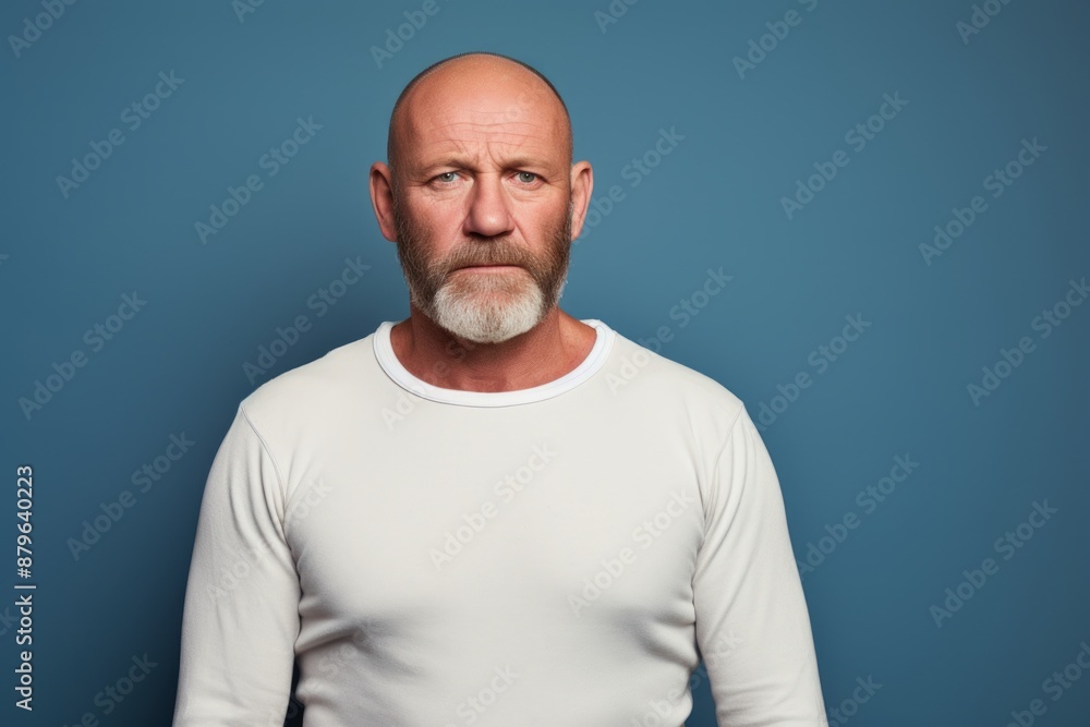 Portrait of a merry man in his 50s sporting a long-sleeved thermal undershirt in front of solid color backdrop Portrait of a merry man in his 50s sporting a long-sleeved thermal undershirt in front of solid color backdrop