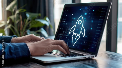 Close-up of hands typing on a laptop with a rocket icon on the screen.