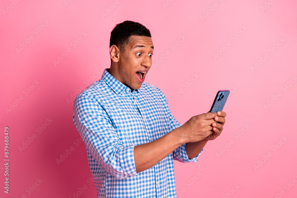 Photo of funky impressed guy dressed checkered shirt getting massages modern device emtpy space isolated pink color background Photo of funky impressed guy dressed checkered shirt getting massages modern device emtpy space isolated pink color background
