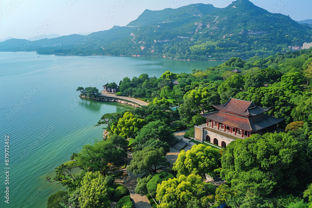Fototapeta premium An aerial view of a beautiful Chinese garden with a lake, trees, and a pavilion.